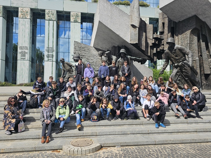 Uczniowie pozują w czasie wycieczki do Warszawy