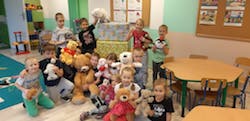dzieci trzymają pluszowe misie