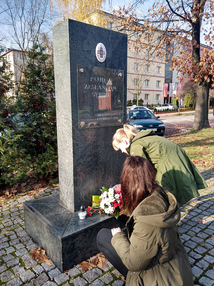 Uczennice składają znicze pod pomnikiem