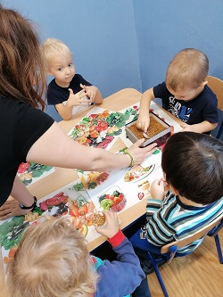 dzieci siedzą przy stoliku oglądając bursztyn