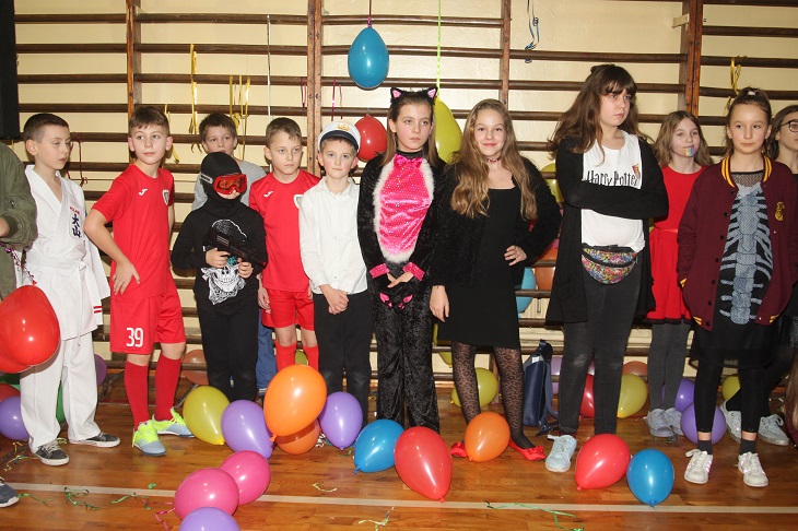 Uczniowie stoją w przebraniach karnawałowych