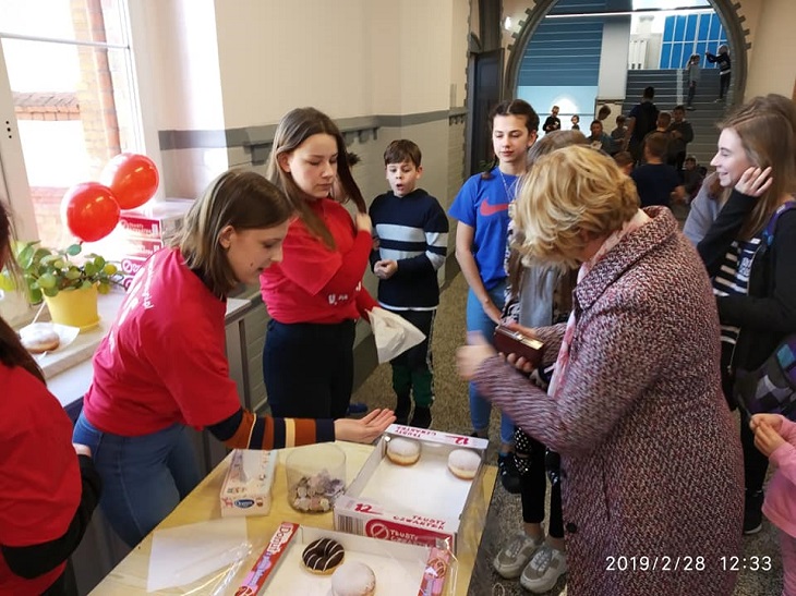 Uczennice sprzedają pączki na korytarzu szkolnym