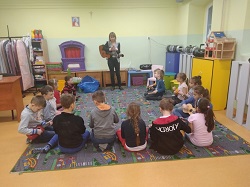 Dzieci siedzą na dywanie z gitarami