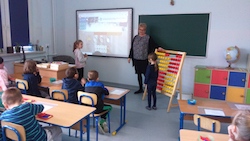 dzieci liczą na liczydle i wpisują wynik działania na tablicy multimedialnej
