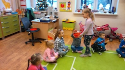 dziewczynka rozdaje pączki dzieciom