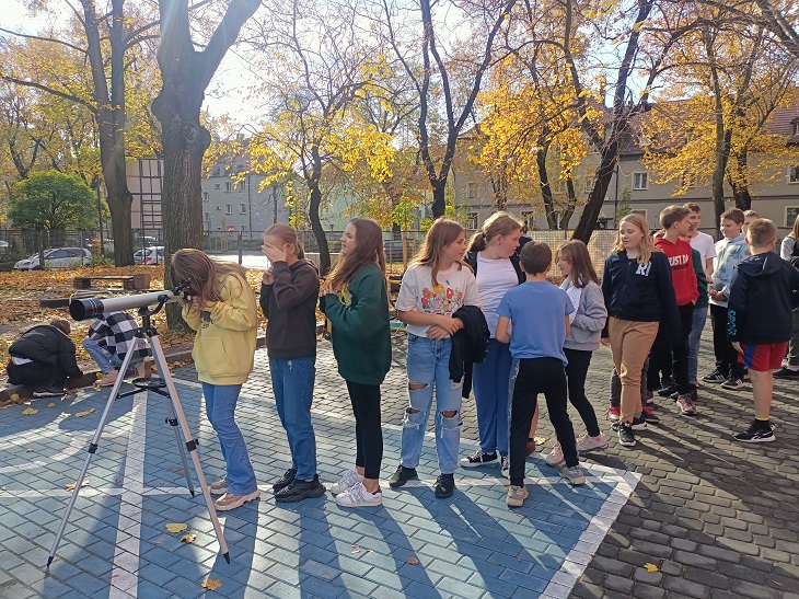 dzieci oglądają przez teleskop