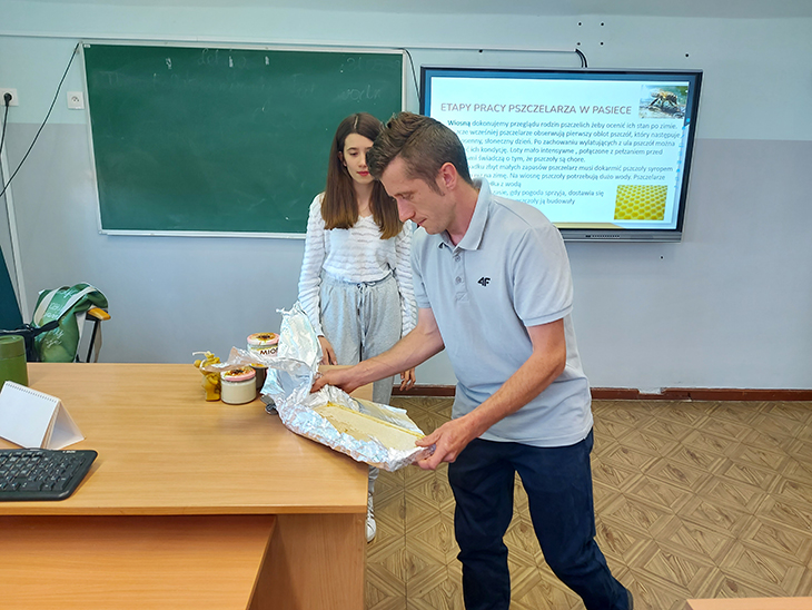 pszczelarz z plastrem miodu