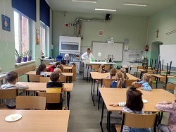 Dzieci siedzą w sali fizycznej.