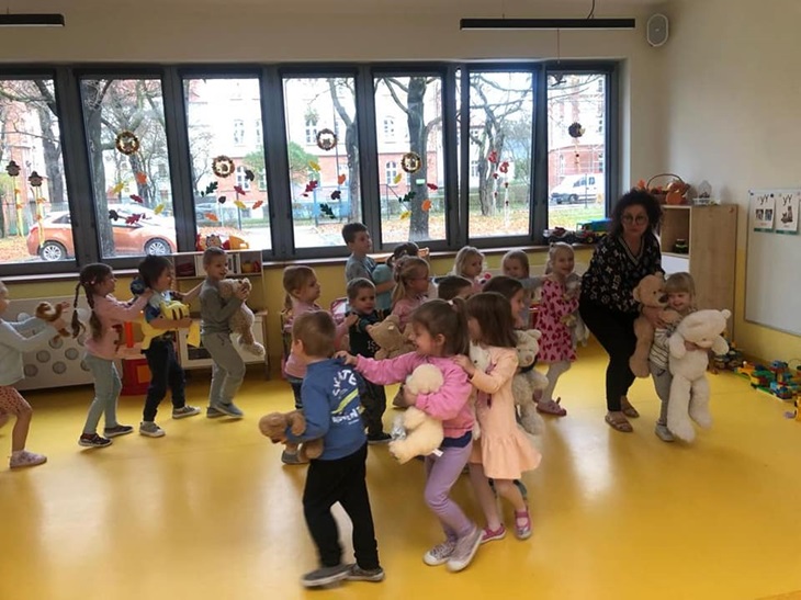 dzieci tańczą w sali z pluszowymi misiami