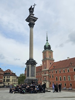 uczniowie pozują na tle kolumny Zygmunta III Wazy