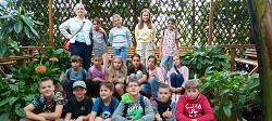Uczestnicy wycieczki do palmiarni wraz z nauczycielką pozują