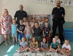 Grupa dzieci z policjantami w sali