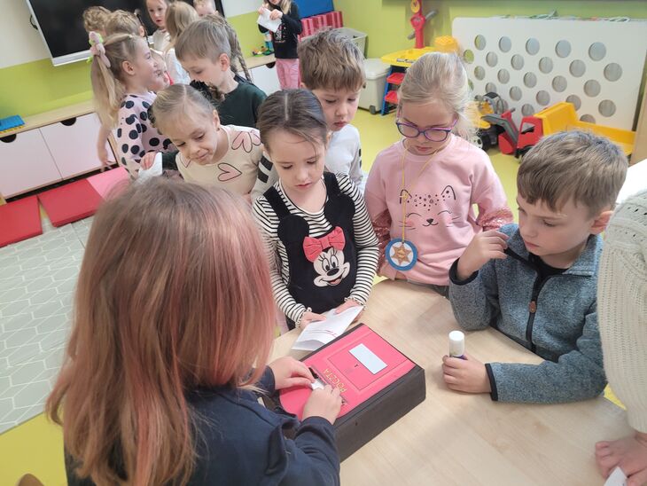 Iskierki wrzucające listy do tekturowej skrzynki 