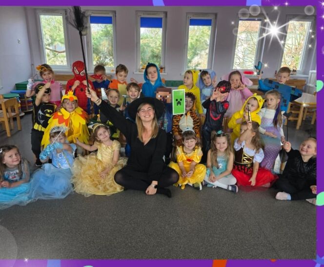 grupa dzieci przebrana w stroje z postaci z bajek. w środku uśmiechnięta nauczycielka w kapeluszu czarownicy