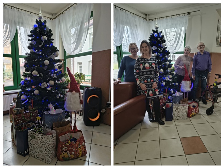 Na zdjęciu widać udekorowaną choinkę otoczoną prezentami oraz kilka osób pozujących w świątecznej, ciepłej atmosferze wewnątrz budynku.