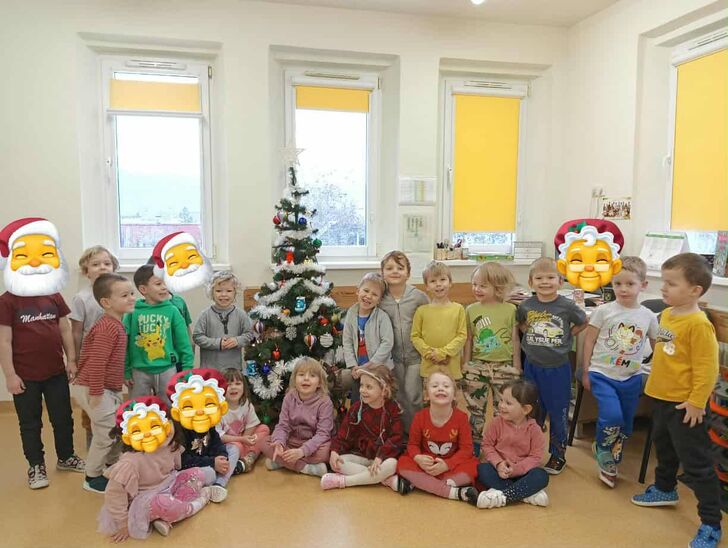 dzieci stojące w sali a dookoła zimowe ozdoby.