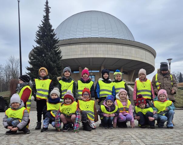 dzieci stojące w grupie pod planetarium