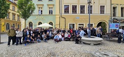 Na zdjęciu widać uczestników wycieczki klas 6 podczas pobytu we Wrocławiu. Uczniowie wraz z opiekunami pozują do wspólnego zdjęcia na rynku otoczonym kolorowymi kamienicami. Większość grupy uśmiecha się do aparatu, co pokazuje dobrą atmosferę i radość ze wspólnie spędzonego czasu. W tle można dostrzec zabytkową zabudowę oraz klimatyczne uliczki Wrocławia, które podkreślają wyjątkowy charakter miasta. To pamiątkowe zdjęcie doskonale oddaje atmosferę wyjazdu pełnego atrakcji, integracji i wspólnych przeżyć.