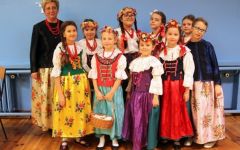 Nauczyciela wraz z dziećmi pozuje w stroju regionalnym