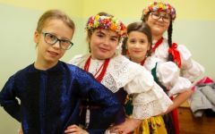 Dziewczynki stoja, rece trzymają na biodrach są w strojach regionalnych