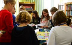 Dzieci oglądają książki. Stoją w kole